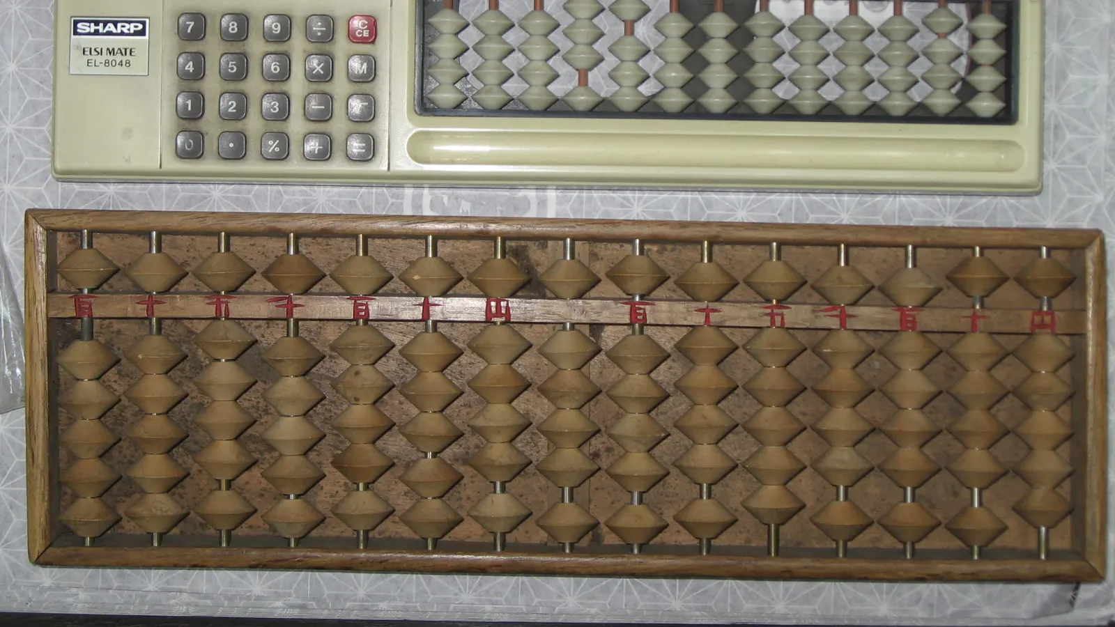 Boulier en bois et calculatrice de bureau côte à côte, deux instruments de calcul d'époques différentes